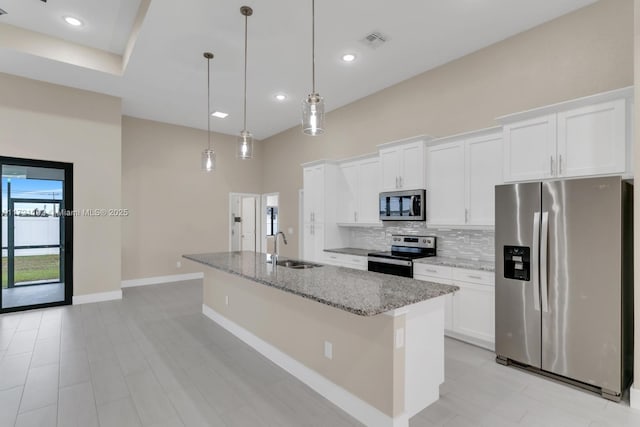 kitchen with sink, stainless steel appliances, white cabinetry, and a kitchen island with sink