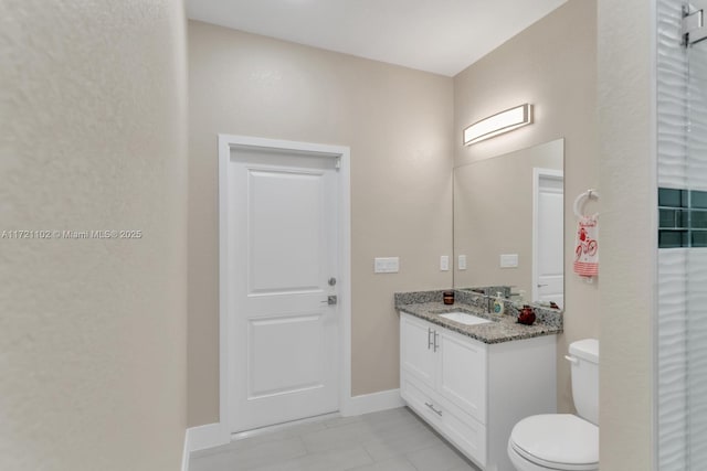 bathroom with toilet, vanity, and tile patterned flooring