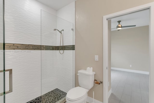 bathroom with toilet, ceiling fan, and tiled shower