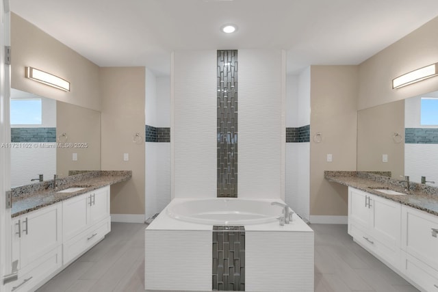 bathroom featuring vanity, tile patterned floors, and tiled bath