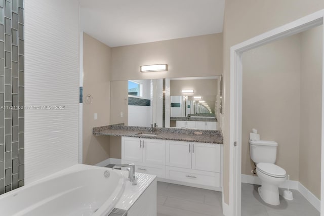 bathroom featuring tile patterned flooring, tiled tub, vanity, and toilet