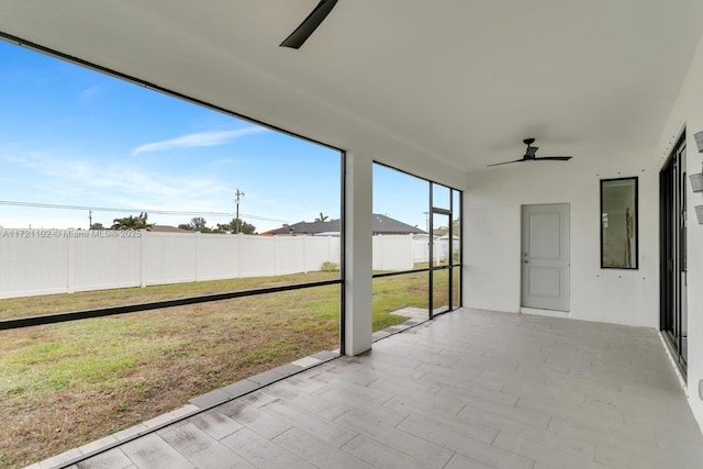 unfurnished sunroom with ceiling fan