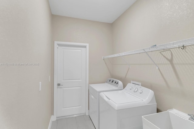 clothes washing area with sink and washer and clothes dryer