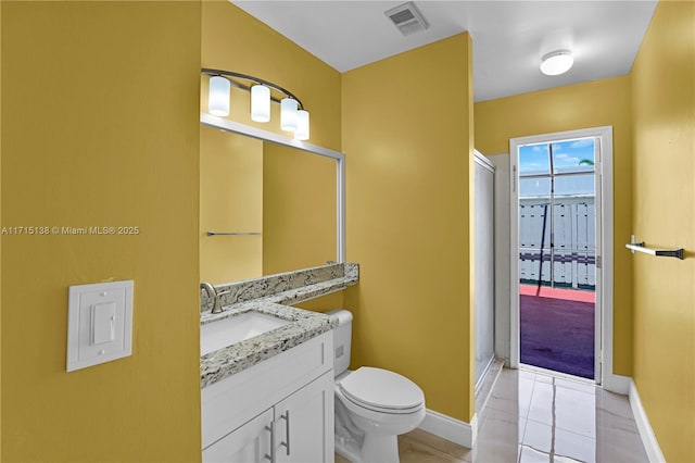 bathroom featuring a shower with door, tile patterned floors, vanity, and toilet