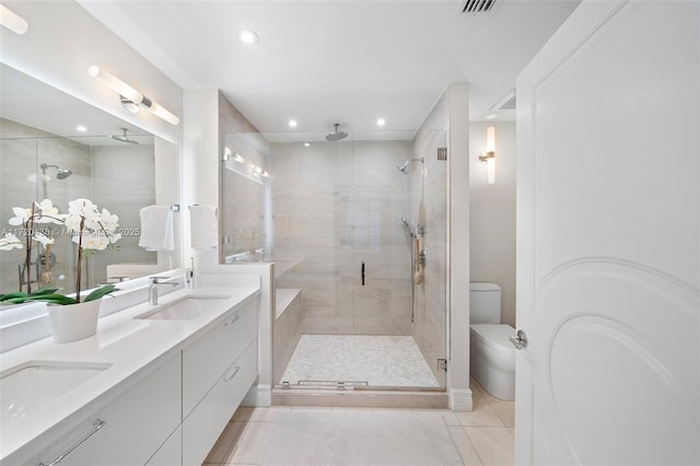 bathroom with toilet, vanity, tile patterned floors, and a shower with door