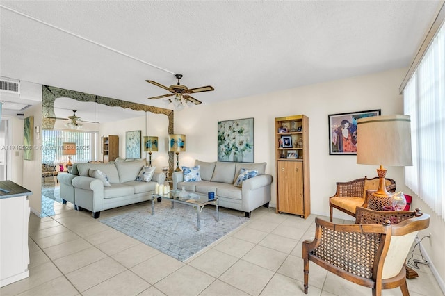 tiled living room with ceiling fan and a textured ceiling