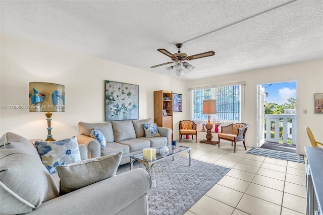 living room featuring ceiling fan, light tile patterned floors, and a textured ceiling