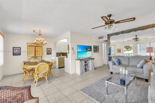 living room with ceiling fan with notable chandelier, light tile patterned flooring, and a textured ceiling