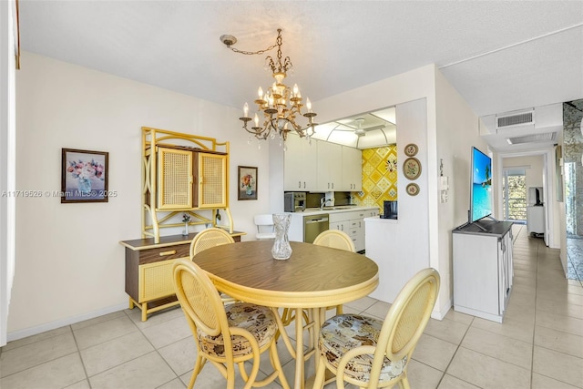 dining area featuring sink, light tile patterned floors, a textured ceiling, and a notable chandelier