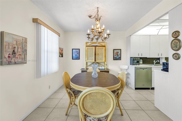 dining space featuring sink, light tile patterned flooring, a textured ceiling, and a notable chandelier