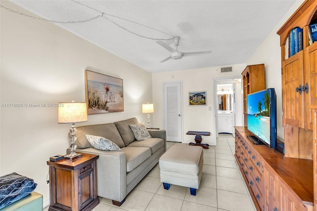 tiled living room with a textured ceiling and ceiling fan