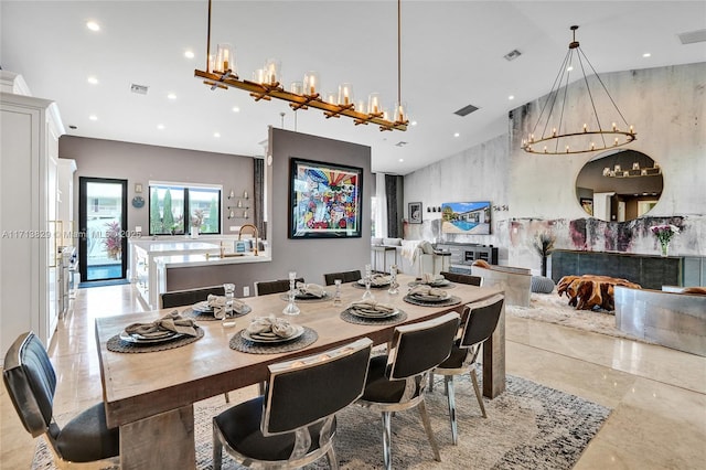 dining area featuring a chandelier and a tiled fireplace