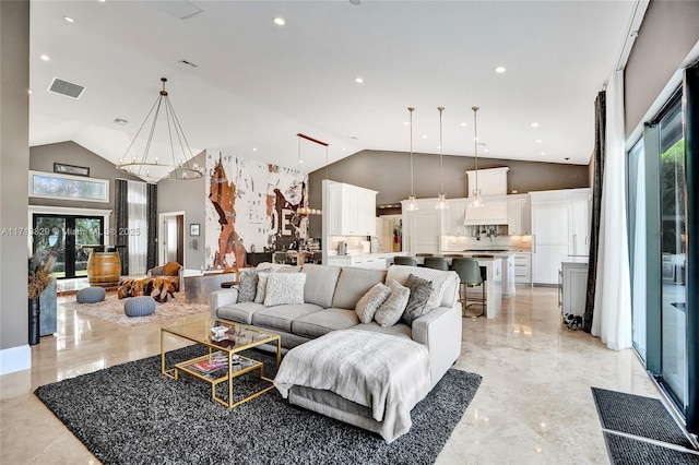 living room featuring a notable chandelier and high vaulted ceiling