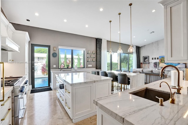 kitchen with white cabinets, a spacious island, and stainless steel stove