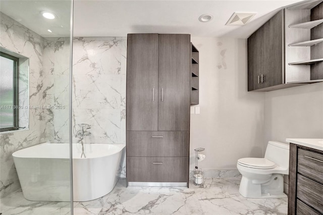 bathroom featuring a washtub, toilet, and vanity