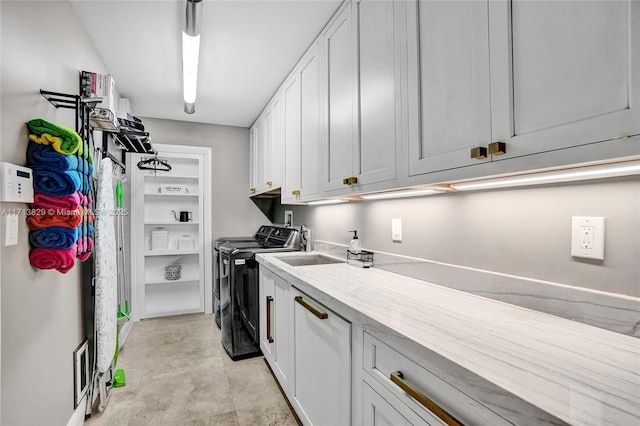 laundry area with separate washer and dryer and cabinets