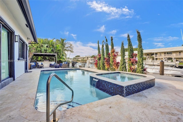 view of pool featuring a patio area and an in ground hot tub