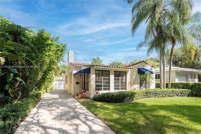 mediterranean / spanish house featuring a front lawn