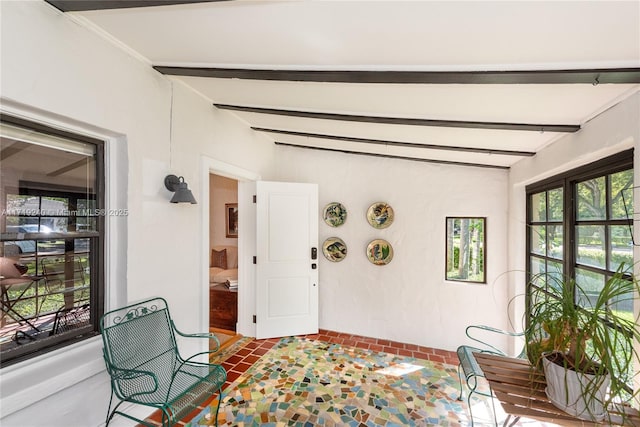 sitting room featuring vaulted ceiling with beams