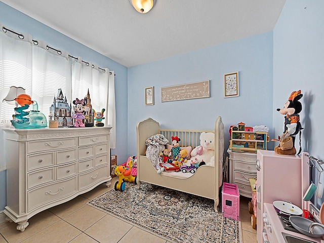 bedroom with a crib and light tile patterned floors
