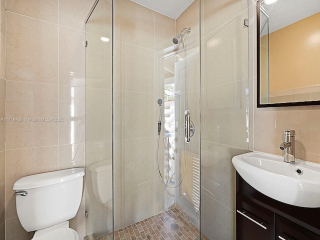 bathroom with walk in shower, a textured ceiling, vanity, tile walls, and toilet