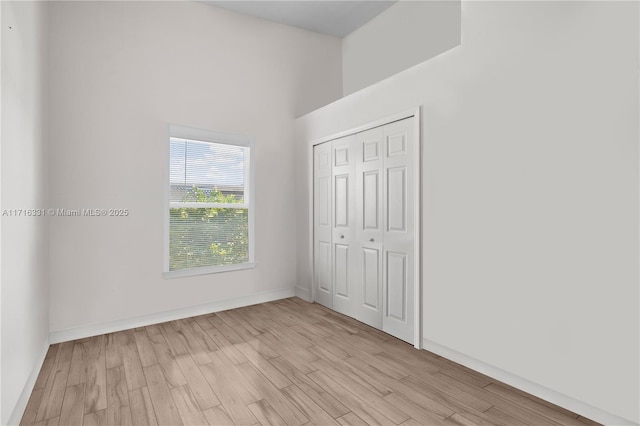 unfurnished bedroom featuring light hardwood / wood-style floors and a closet