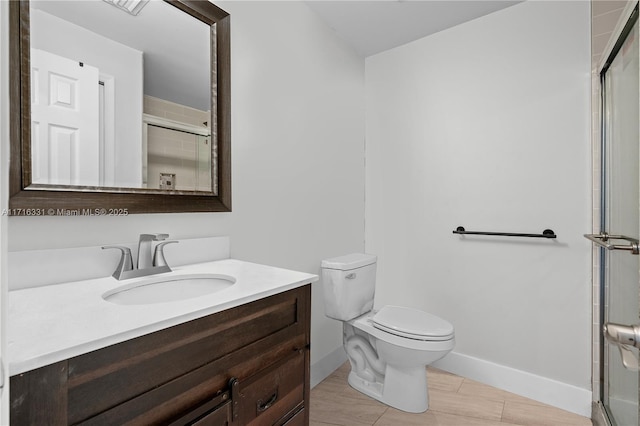 bathroom with tile patterned flooring, vanity, toilet, and a shower with door