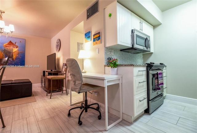 kitchen featuring white cabinets, pendant lighting, appliances with stainless steel finishes, and tasteful backsplash