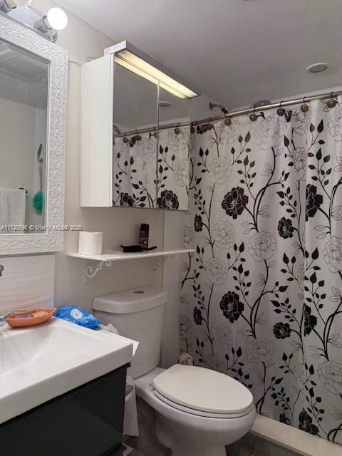 bathroom with vanity, a shower with shower curtain, and toilet