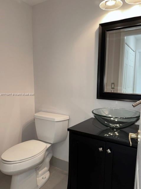 bathroom with tile patterned flooring, vanity, and toilet