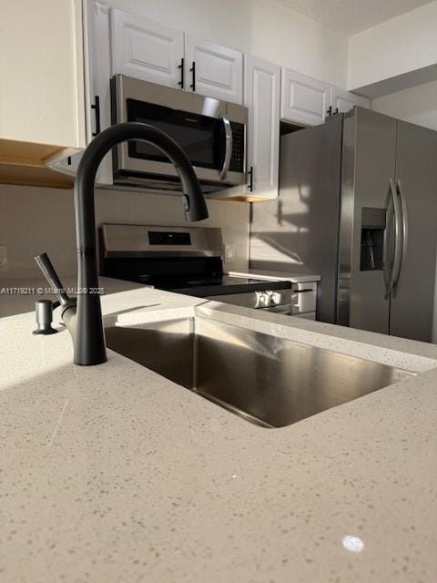 kitchen with white cabinets and appliances with stainless steel finishes