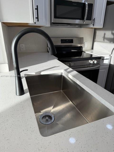 details featuring light stone countertops, sink, and stainless steel appliances