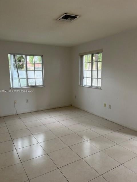 tiled empty room featuring a wealth of natural light