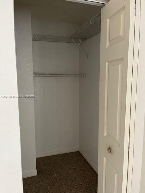 spacious closet featuring dark carpet