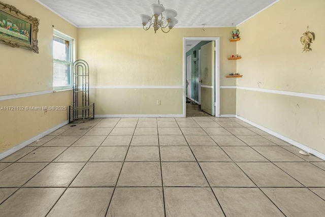 spare room featuring a chandelier, a textured ceiling, ornamental molding, and light tile patterned flooring