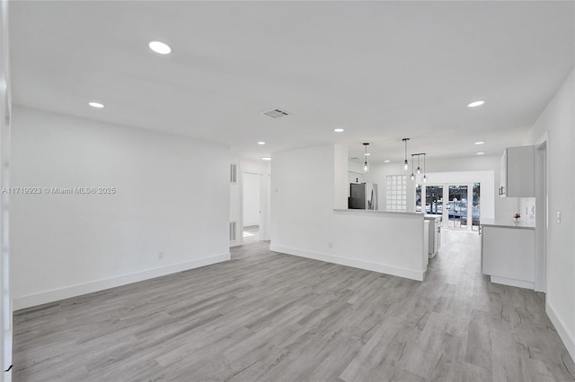 unfurnished living room with light wood-type flooring, visible vents, and recessed lighting