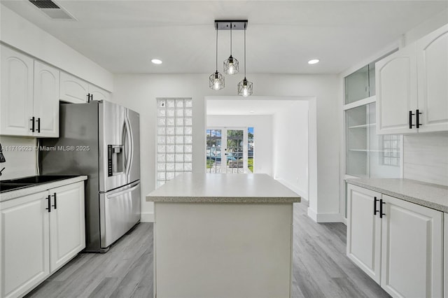 kitchen featuring light wood-style floors, visible vents, a kitchen island, and stainless steel refrigerator with ice dispenser