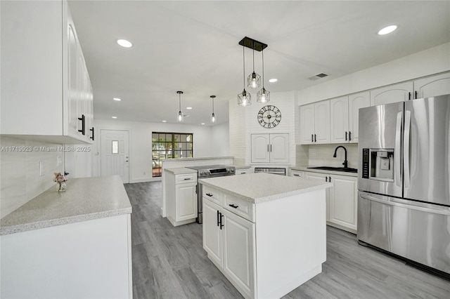 kitchen with appliances with stainless steel finishes, white cabinets, visible vents, and backsplash