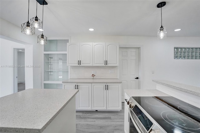 kitchen with recessed lighting, white cabinets, light wood-type flooring, double oven range, and pendant lighting