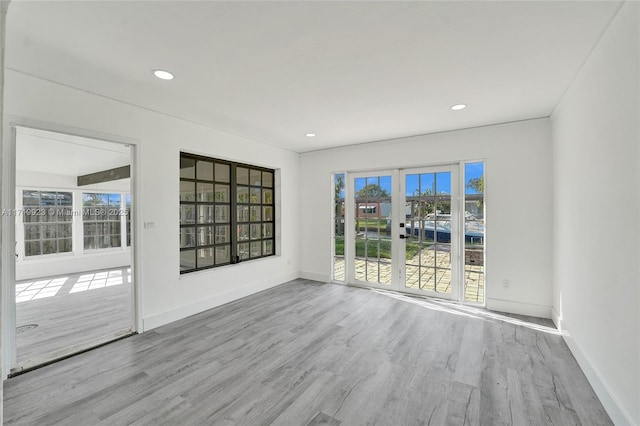 empty room with french doors and light wood-type flooring