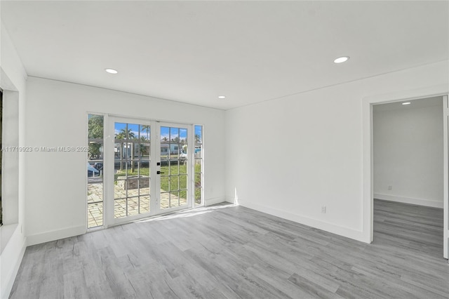 unfurnished room with recessed lighting, baseboards, and wood finished floors