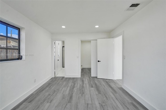 unfurnished bedroom featuring recessed lighting, visible vents, baseboards, and wood finished floors