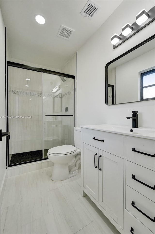 bathroom with vanity, toilet, and an enclosed shower