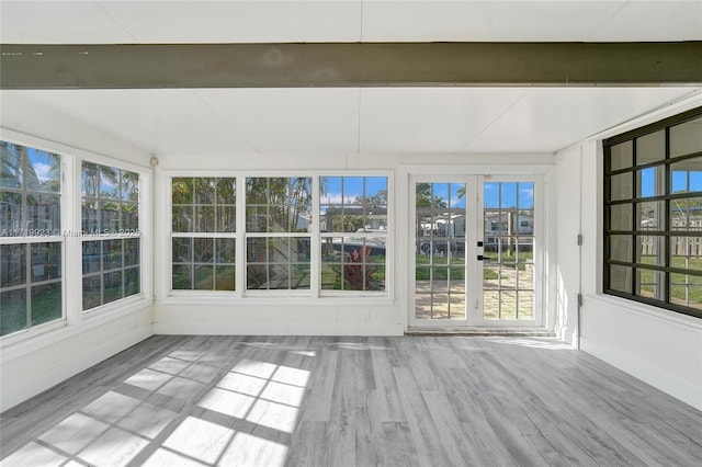 unfurnished sunroom with plenty of natural light and beamed ceiling