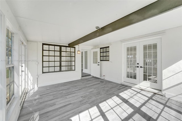 interior space with french doors, light hardwood / wood-style floors, and beam ceiling