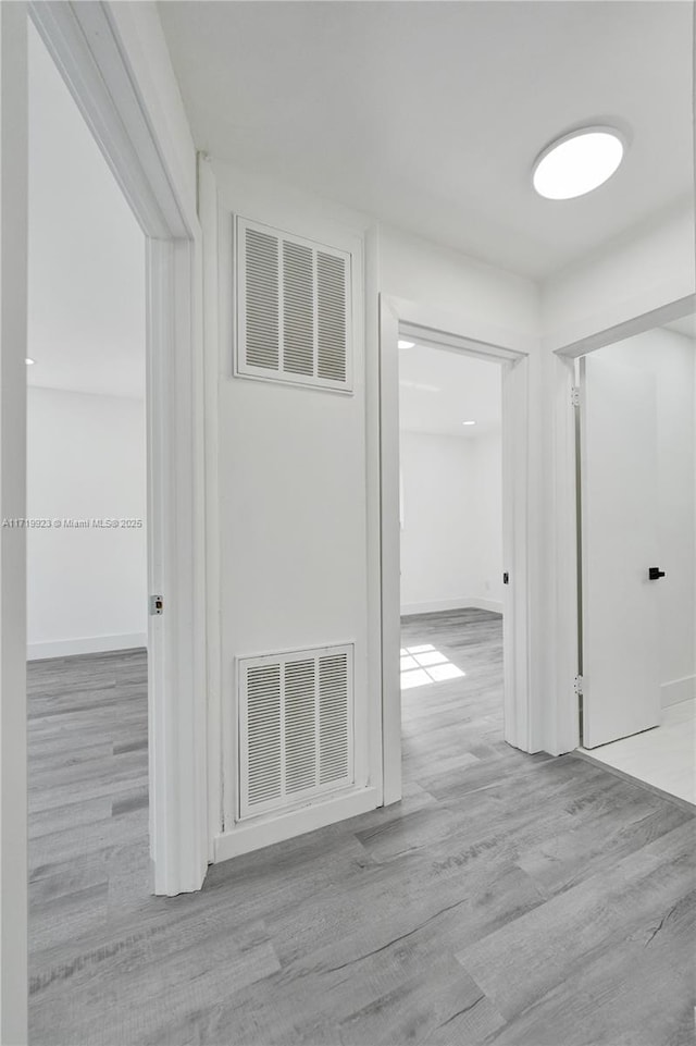 corridor featuring visible vents and wood finished floors