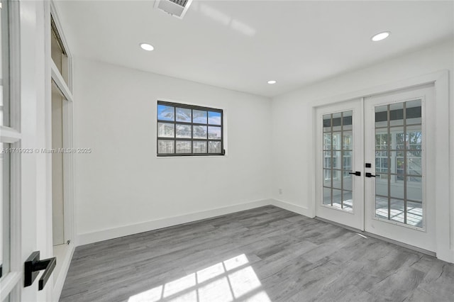 spare room with light wood-type flooring and french doors