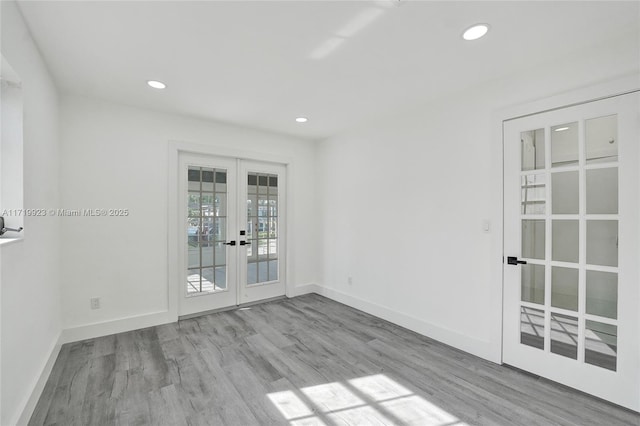 empty room with recessed lighting, french doors, baseboards, and wood finished floors