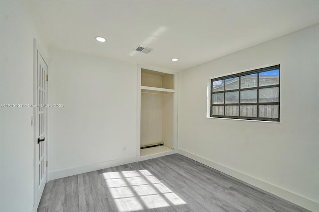 unfurnished bedroom with light wood-type flooring and a closet