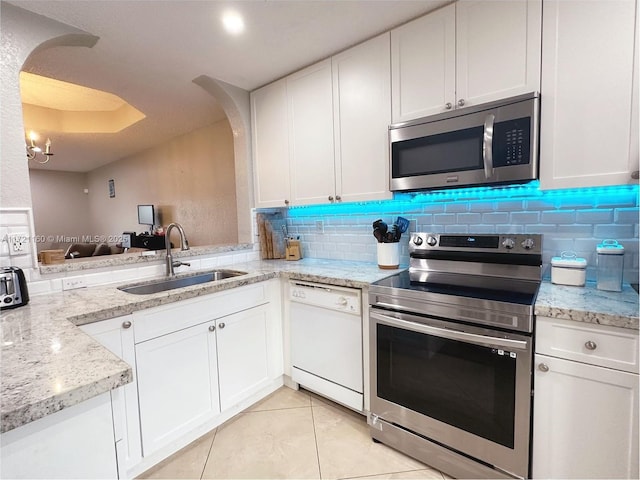 kitchen with white cabinetry, sink, stainless steel appliances, an inviting chandelier, and tasteful backsplash